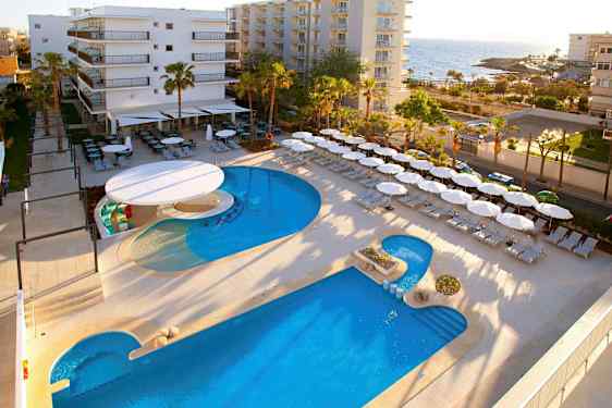 Hotellområde nära havet med pool, solstolar och parasoller. (AI-genererad text)