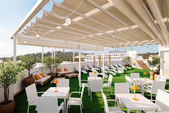 En takterrass med vita bord och stolar, solsängar och växter, täckt av ett skärmtak. (AI-genererad text)