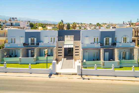 Bild av en modern byggnad med två våningar, omgiven av en trädgård och med en central ingång som vetter mot en gata. (AI-genererad text)