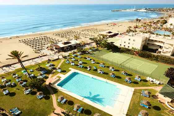 Hotellets poolområde med utsikt över stranden och havet. (AI-genererad text)