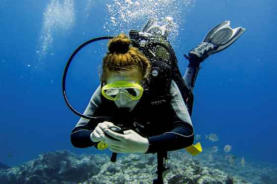 En person som dyker under vattnet, med dykutrustning och luftbubblor synliga. (AI-genererad text)