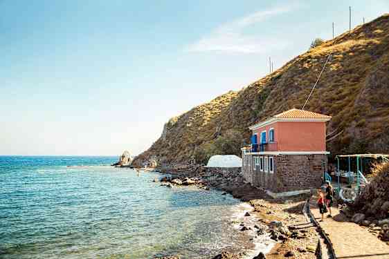 Hus vid havet bredvid en klippa. (AI-genererad text)