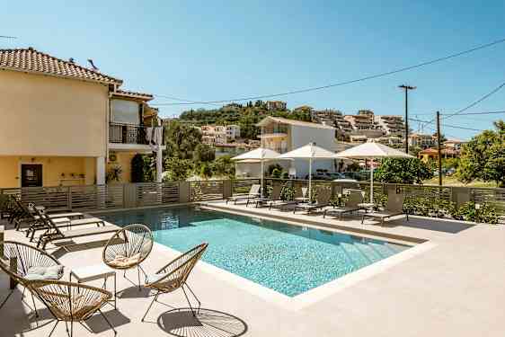 Utomhuspool med solstolar och parasoller vid ett bostadsområde. (AI-genererad text)