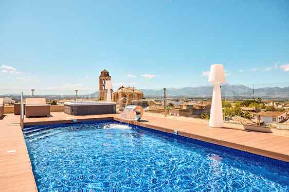 Utomhuspool med utsikt över staden och bergen. (AI-genererad text)