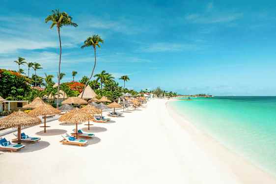 En strand med parasoll och solstolar vid turkost vatten. (AI-genererad text)