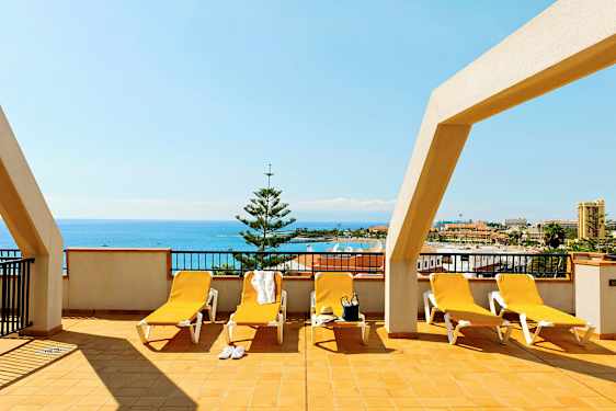 Terrass med solstolar och havsutsikt. (AI-genererad text)