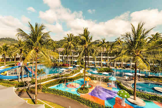 Bild av ett hotellområde med pooler, vattenrutschbana och färgglada lekområden omgiven av palmträd. (AI-genererad text)