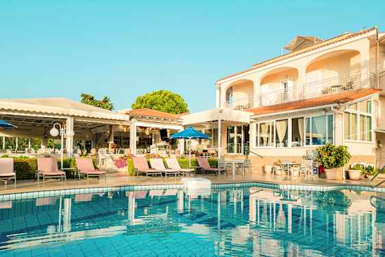 Exteriör av hotell med pool och solstolar. (AI-genererad text)