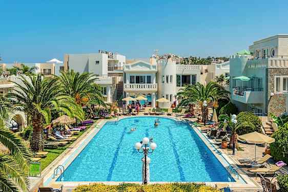 En pool omgiven av palmer, solstolar och byggnader under en klarblå himmel. (AI-genererad text)