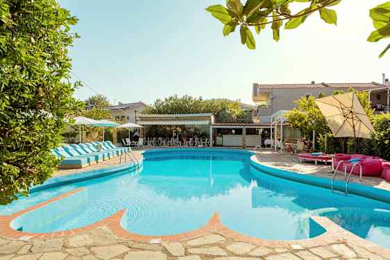 Bild av en utomhuspool omgiven av solstolar och parasoller, med en byggnad i bakgrunden. (AI-genererad text)