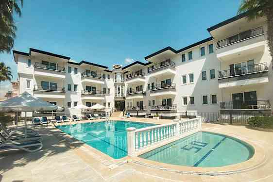En lägenhetsbyggnad med balkonger mot en poolområde. (AI-genererad text)