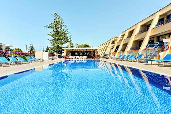 Ett hotellområde med en pool i förgrunden, solstolar på båda sidor och en bar i bakgrunden. (AI-genererad text)