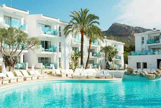 Bild av ett hotell med vita byggnader, en pool och solstolar, omgiven av palmer. (AI-genererad text)