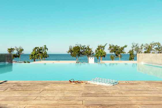 Bild av en infinitypool med utsikt över havet och träd i bakgrunden. (AI-genererad text)