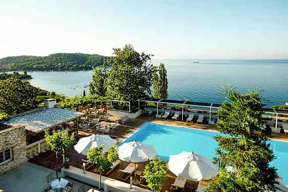 Simhall med parasoller och utsikt över havet. (AI-genererad text)