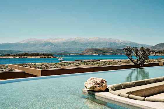 En infinitypool med utsikt över havet och en bergskedja i bakgrunden. (AI-genererad text)