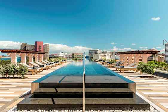 En takpool med solstolar och utsikt över staden under blå himmel. (AI-genererad text)