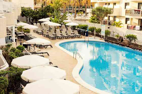 Poolområde med solstolar och parasoller vid ett hotell. (AI-genererad text)