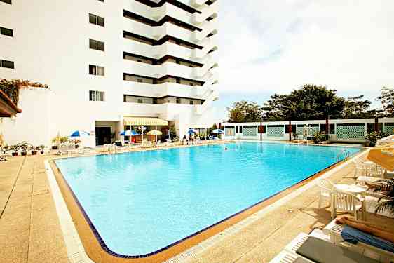 Utomhuspool vid ett hotell med solstolar och parasoller. (AI-genererad text)