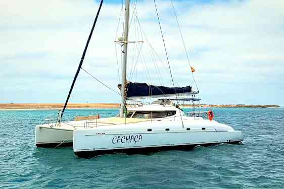 En segelbåt vid en vattenyta under en ljus himmel. (AI-genererad text)