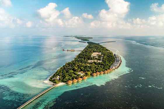 Flygfoto av en tropisk ö med villor över vattnet och turkost hav. (AI-genererad text)