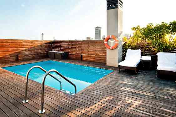 En takterrass med en liten pool, omgiven av ett trädäck och solstolar. (AI-genererad text)