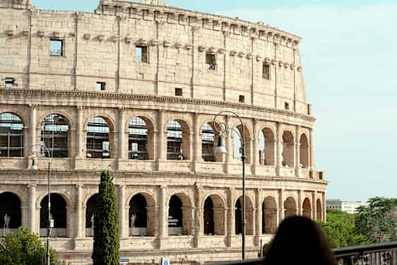Bild av Colosseum i Rom, Italien, med en kvinna i förgrunden. (AI-genererad text)