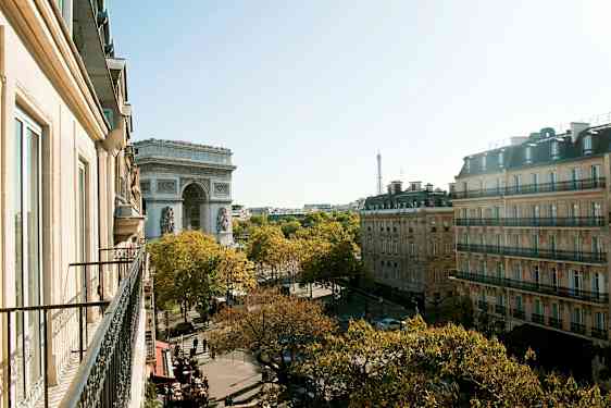 Vy från en balkong över Paris med Triumfbågen och Eiffeltornet. (AI-genererad text)