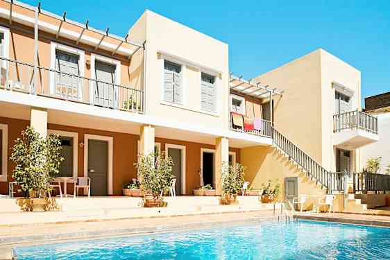 Bild av en byggnad med lägenhetsbalkonger och en pool i förgrunden. (AI-genererad text)