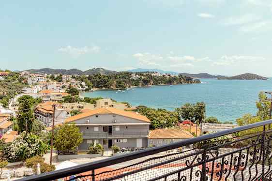 Utsikt över en kuststad med röda tak och havet i bakgrunden. (AI-genererad text)