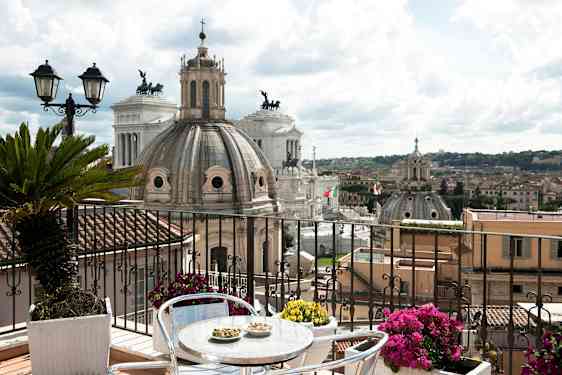 Bild av en terrass med utsikt över Roms arkitektur, inklusive kupoler och monument. (AI-genererad text)