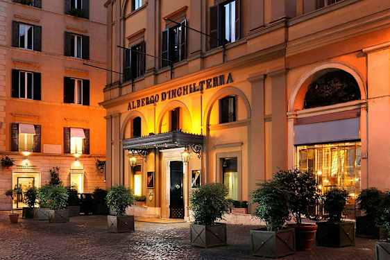 Ett hotell med en arkad framför ingången, belyst på kvällen. (AI-genererad text)