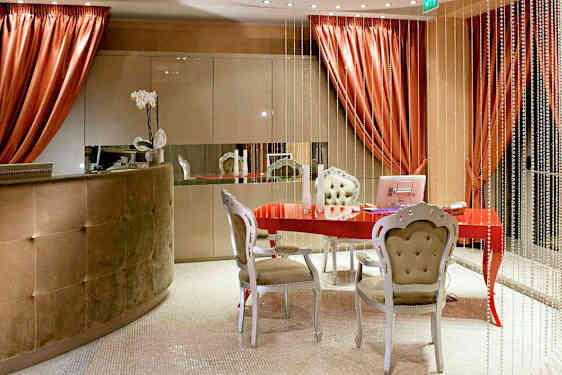 Ett välkomnande rum med ett rött bord, elegant möbler och dekorativa element. (AI-genererad text)