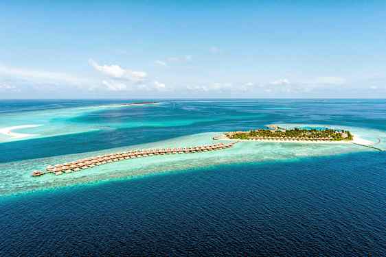 Flygfoto av en tropisk ö och villor på pålar i klarblått hav. (AI-genererad text)