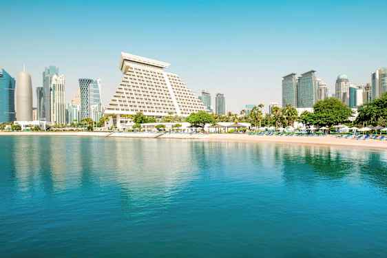 Bild av en stad med modern arkitektur vid en lugn strand och vatten. (AI-genererad text)