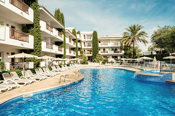 Bild av en utomhuspool omgiven av solstolar och parasoller, med ett hotell i bakgrunden. (AI-genererad text)