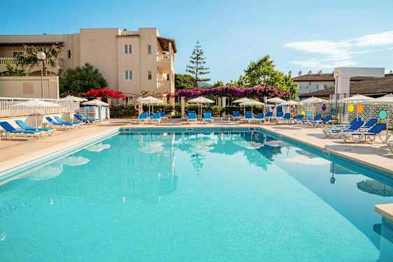 En utomhuspool omgiven av solstolar och parasoller vid ett hotell. (AI-genererad text)