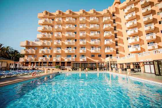 Byggnad med flera balkonger och en stor pool framför. (AI-genererad text)