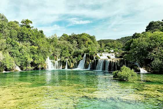 Ett naturskönt vattenfall omringat av frodig grönska. (AI-genererad text)
