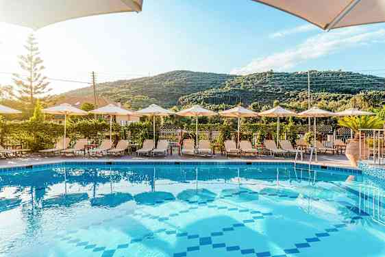 Pool med solstolar och parasoller framför en grön bergsutsikt. (AI-genererad text)