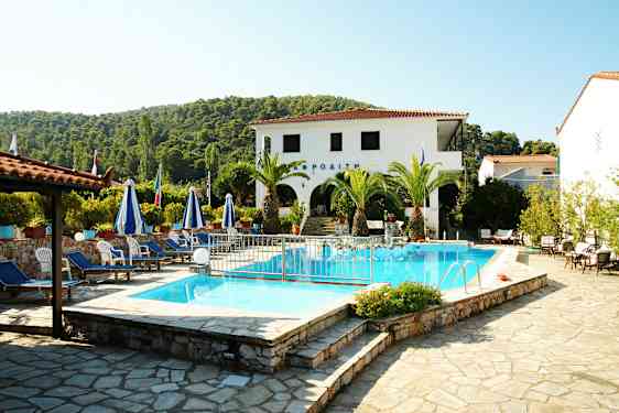 En poolområde med solsängar och parasoller omgivna av palmer och vegetationsrik omgivning. (AI-genererad text)