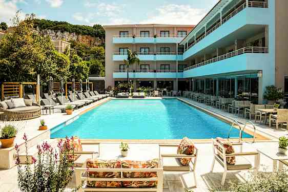 En utomhuspool omgiven av solstolar och parasoller vid ett modernt hotell. (AI-genererad text)