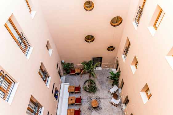 En innergård sedd uppifrån med bord, stolar, och träd. (AI-genererad text)