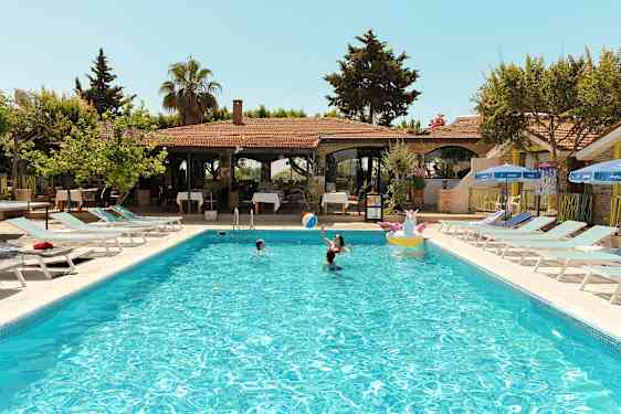 Utomhuspool med människor som badar vid en semesteranläggning. (AI-genererad text)