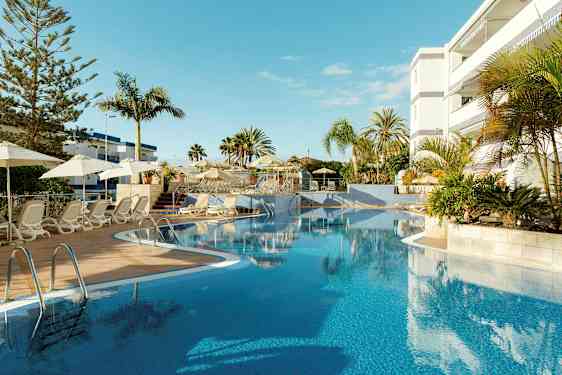 Utomhuspool med solstolar och parasoller vid ett hotell. (AI-genererad text)