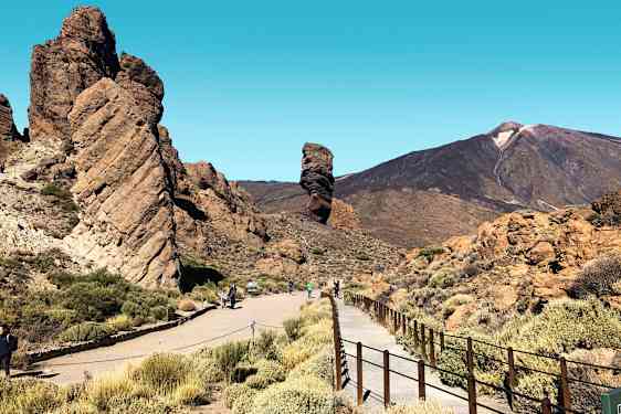 En stenformation med gångväg och berg i bakgrunden. (AI-genererad text)