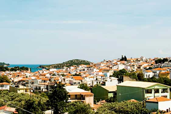 Panoramavy av en stad med vita byggnader och röda tak nära kusten. (AI-genererad text)