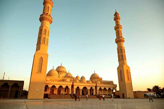 En stor moské med två höga minareter och kupoler. (AI-genererad text)