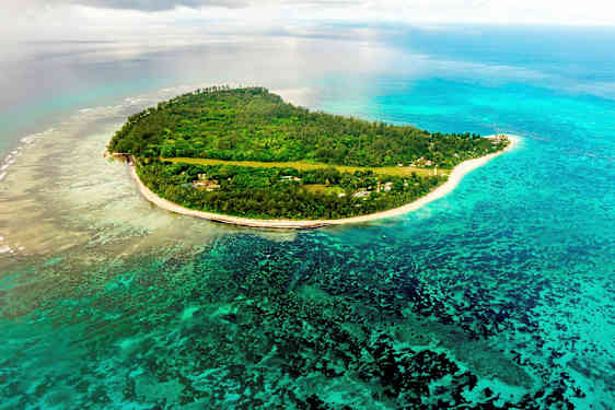 Luftvy över en tropisk ö, omgiven av blått hav och korallrev. (AI-genererad text)