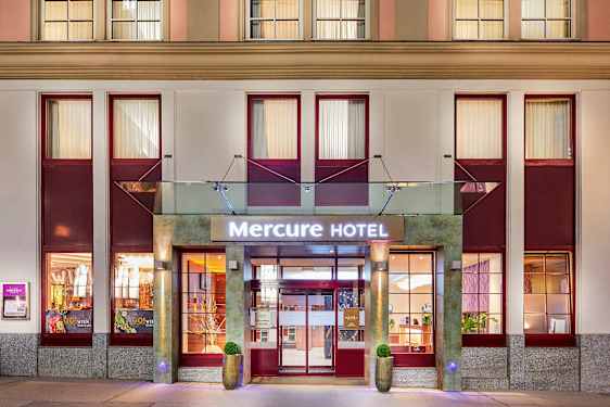 Entrén till Mercure Hotel med skylt och fasad. (AI-genererad text)